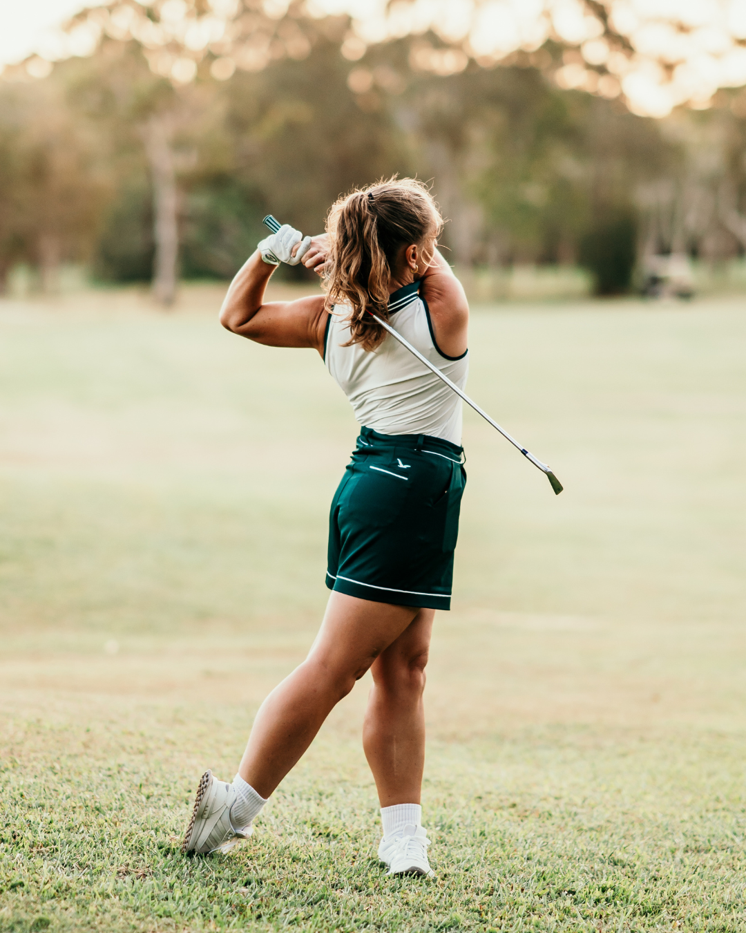 Margie Polo in white with Evergreen details, paired with Stella Shorts for a coordinated, high-performance golf outfit.